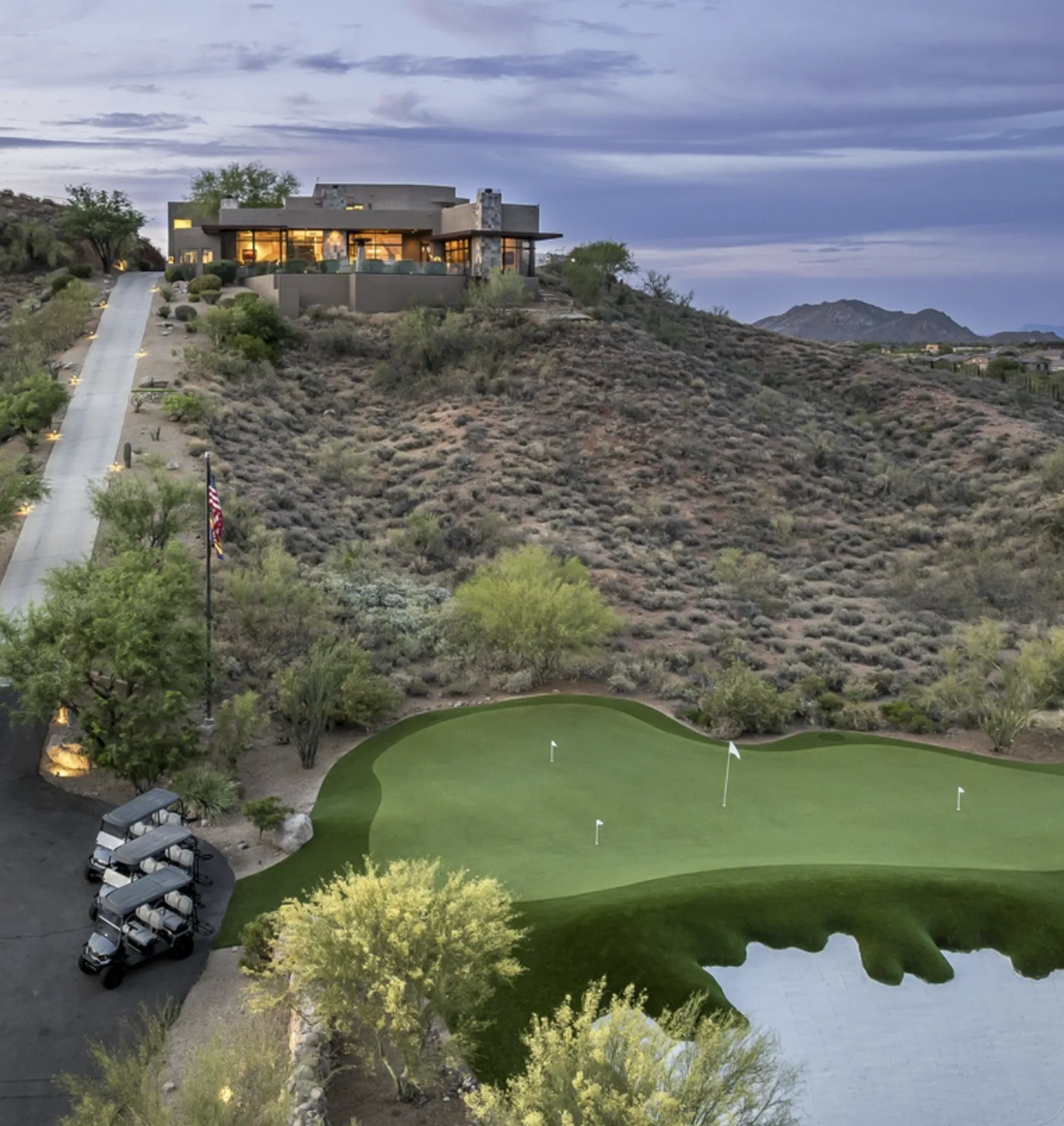 The lighted estate driveway and golf carts at dusk